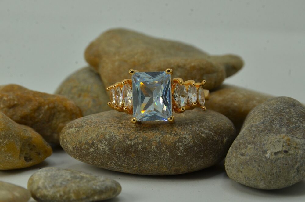Gold-plated zircon ring featuring a large emerald-cut center stone flanked by marquise-cut side accents for a luxurious look.