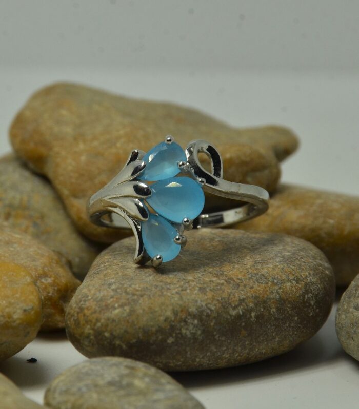Elegant silver ring featuring three pear-shaped blue zircon stones in a floral-inspired design.