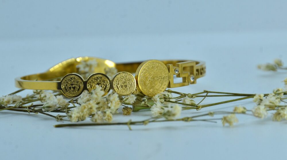 Gold-plated bracelet adorned with engraved Medusa-style coin motifs and a geometric clasp accented - Image 2