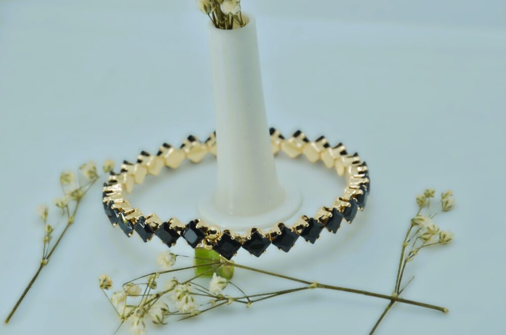 Gold-plated bracelet featuring a sleek zigzag design with square-cut black stones for a bold, modern look