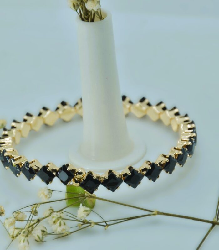Gold-plated bracelet featuring a sleek zigzag design with square-cut black stones for a bold, modern look