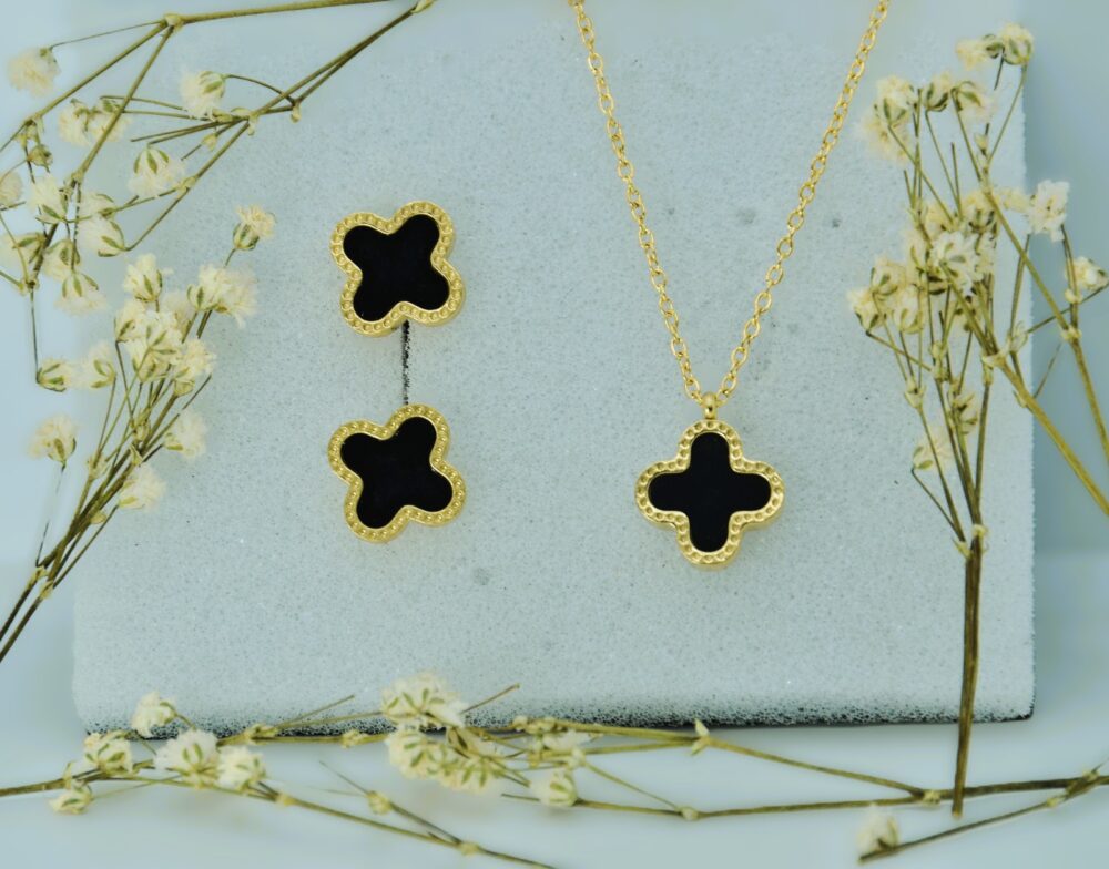 Elegant gold jewelry set featuring a black clover-shaped pendant and matching stud earrings with textured borders. - Image 2