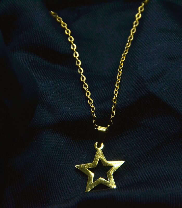 Charming gold jewelry set featuring a hollow star pendant and matching stud earrings for a playful, elegant look.
