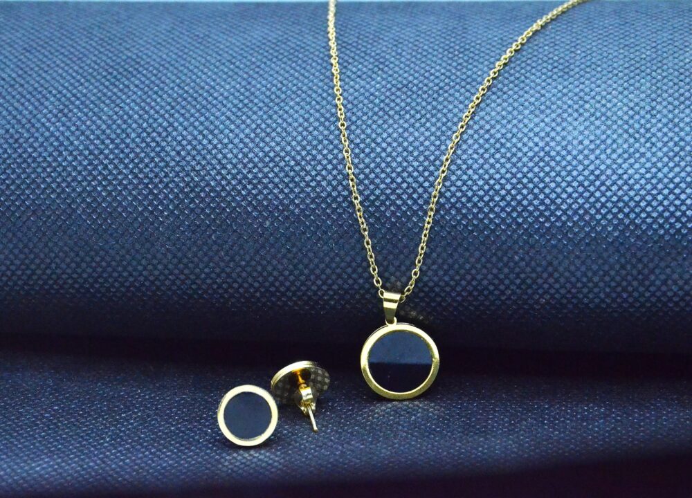 Elegant gold jewelry set with a round black enamel pendant and matching stud earrings - Image 2