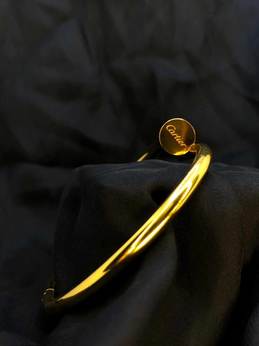 Stylish gold Cartier nail bracelet featuring a sleek, industrial-inspired design with a polished finish