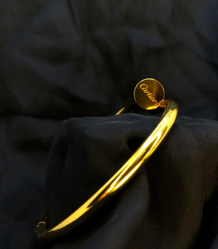 Stylish gold Cartier nail bracelet featuring a sleek, industrial-inspired design with a polished finish